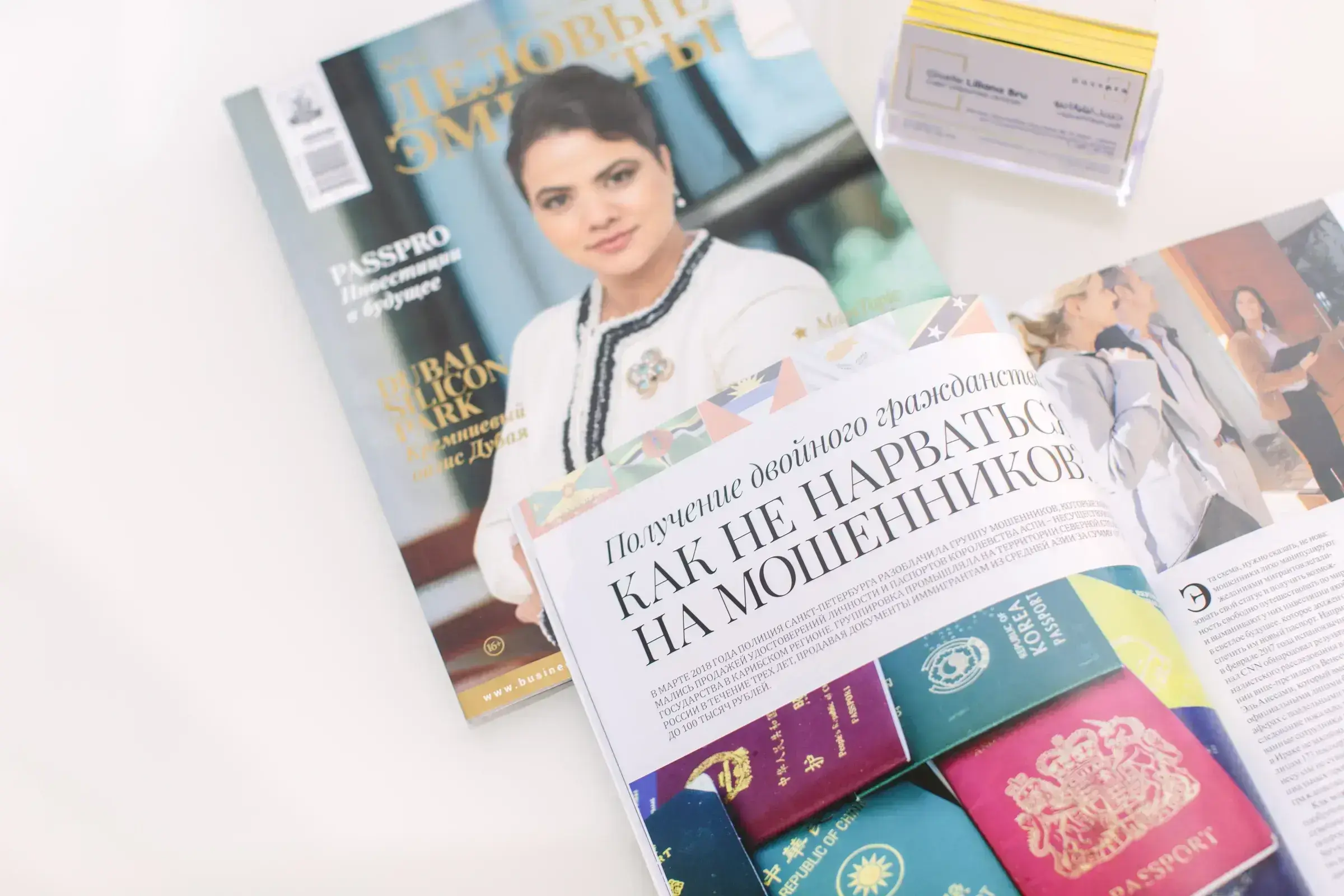 Giselle Bru on the cover of Business Emirates magazine, named for PassPro, beside an open editorial spread on second citizenship and four international passports.