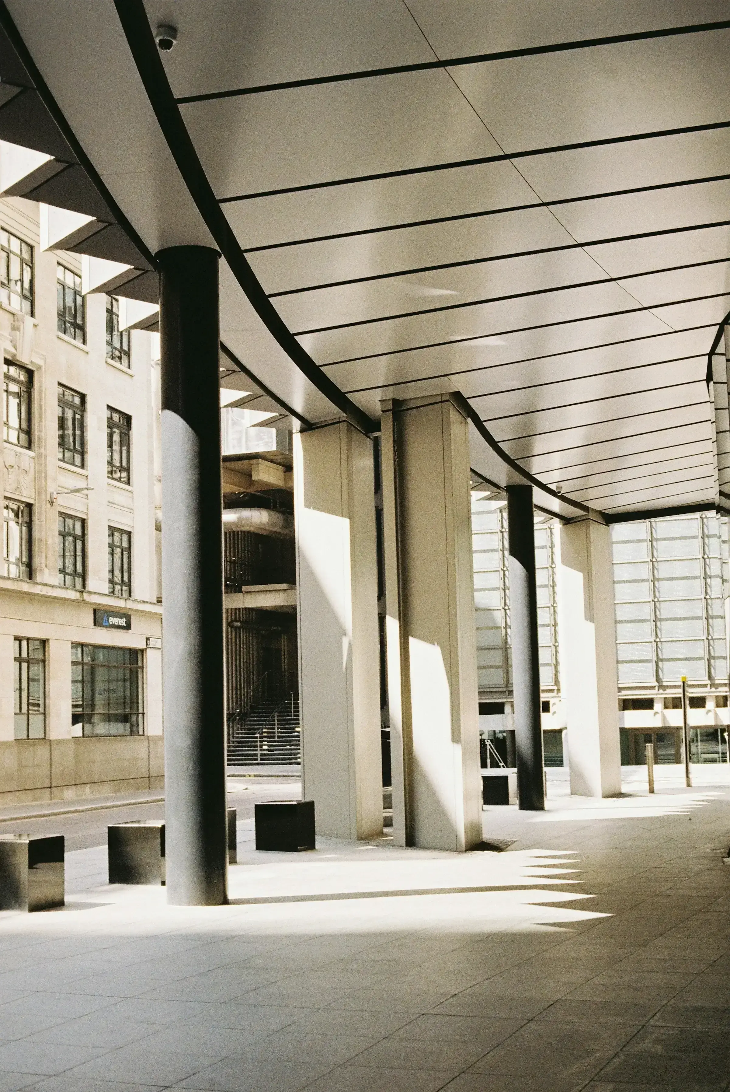 A stylish, empty arcade in a financial district — clean lines, restrained light, suggesting the regulated environments where tax and residency questions live.