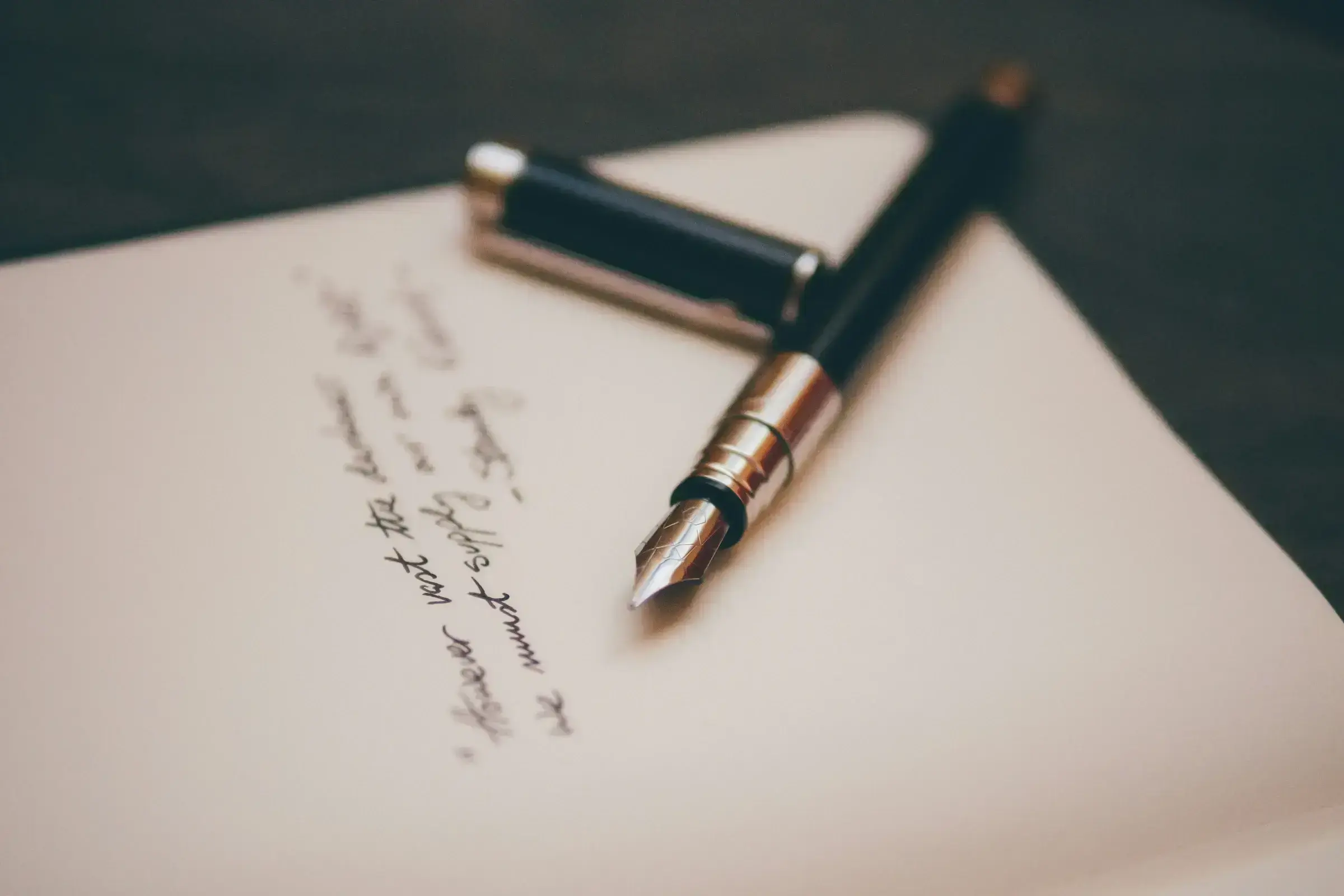 A fountain pen resting on a handwritten page of cream paper — the quiet shape of a considered answer.