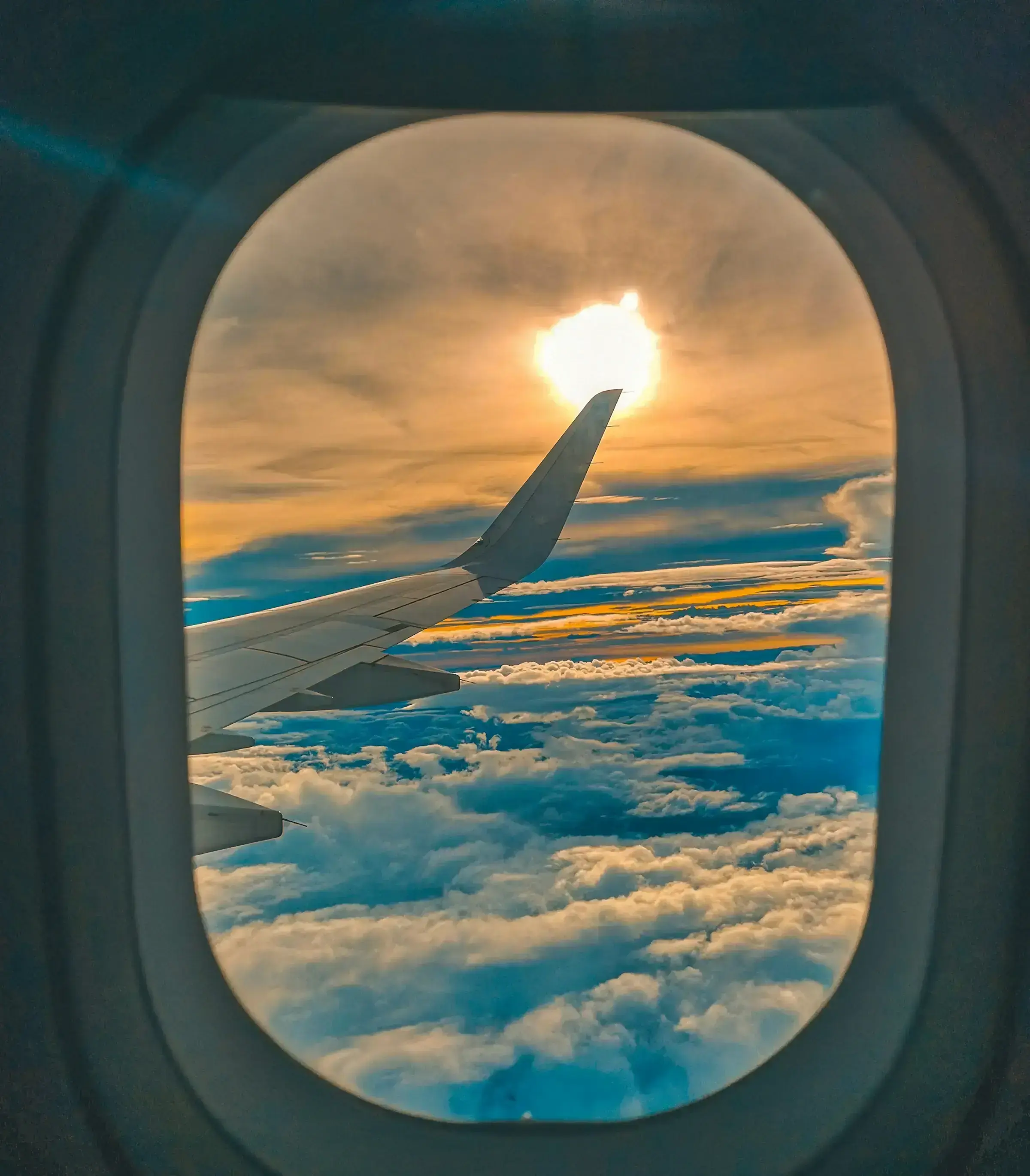 A view of clouds and sky from an aircraft window in mid-flight.