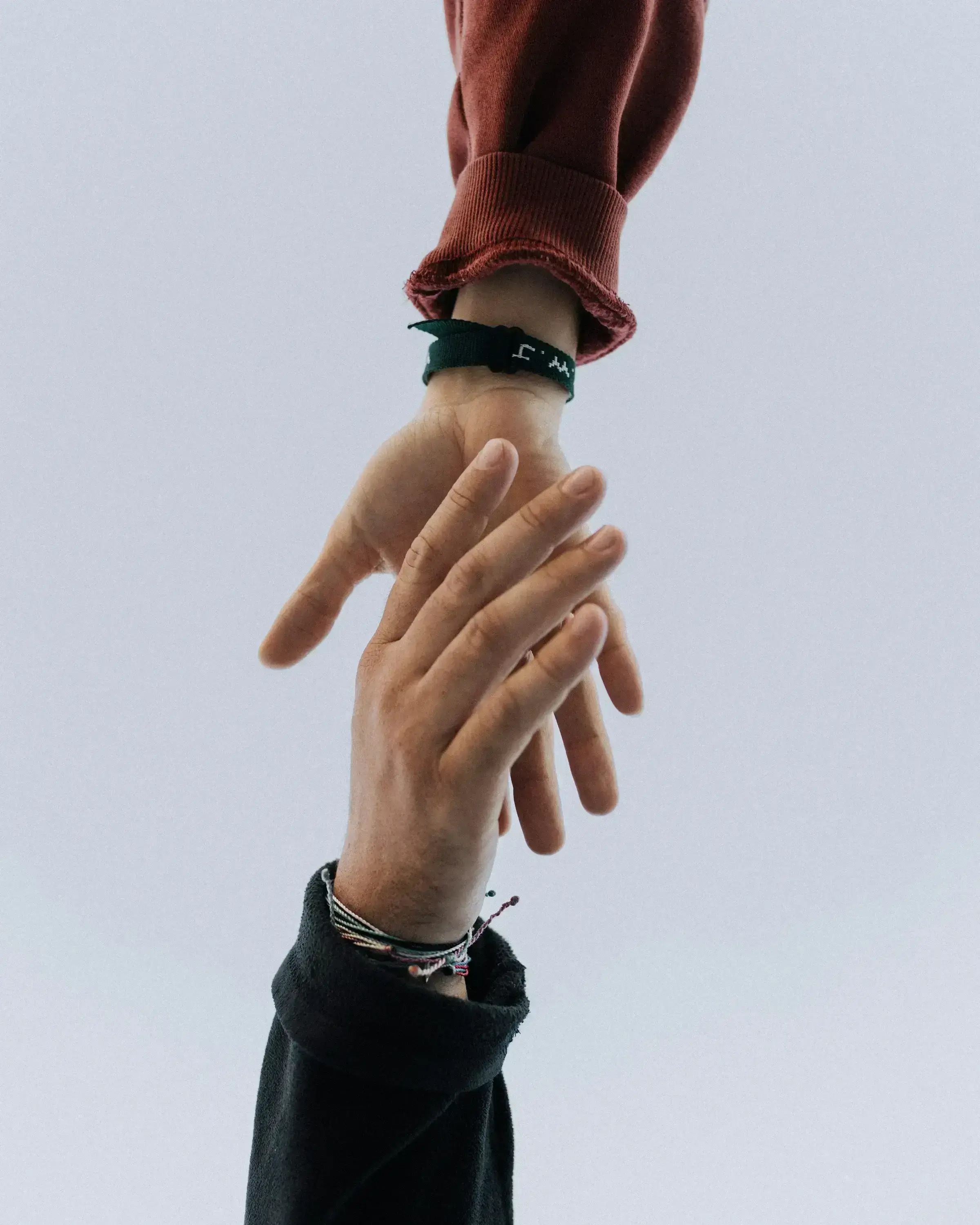 An advisor's hand offering a pen across a desk — the moment of formal engagement.