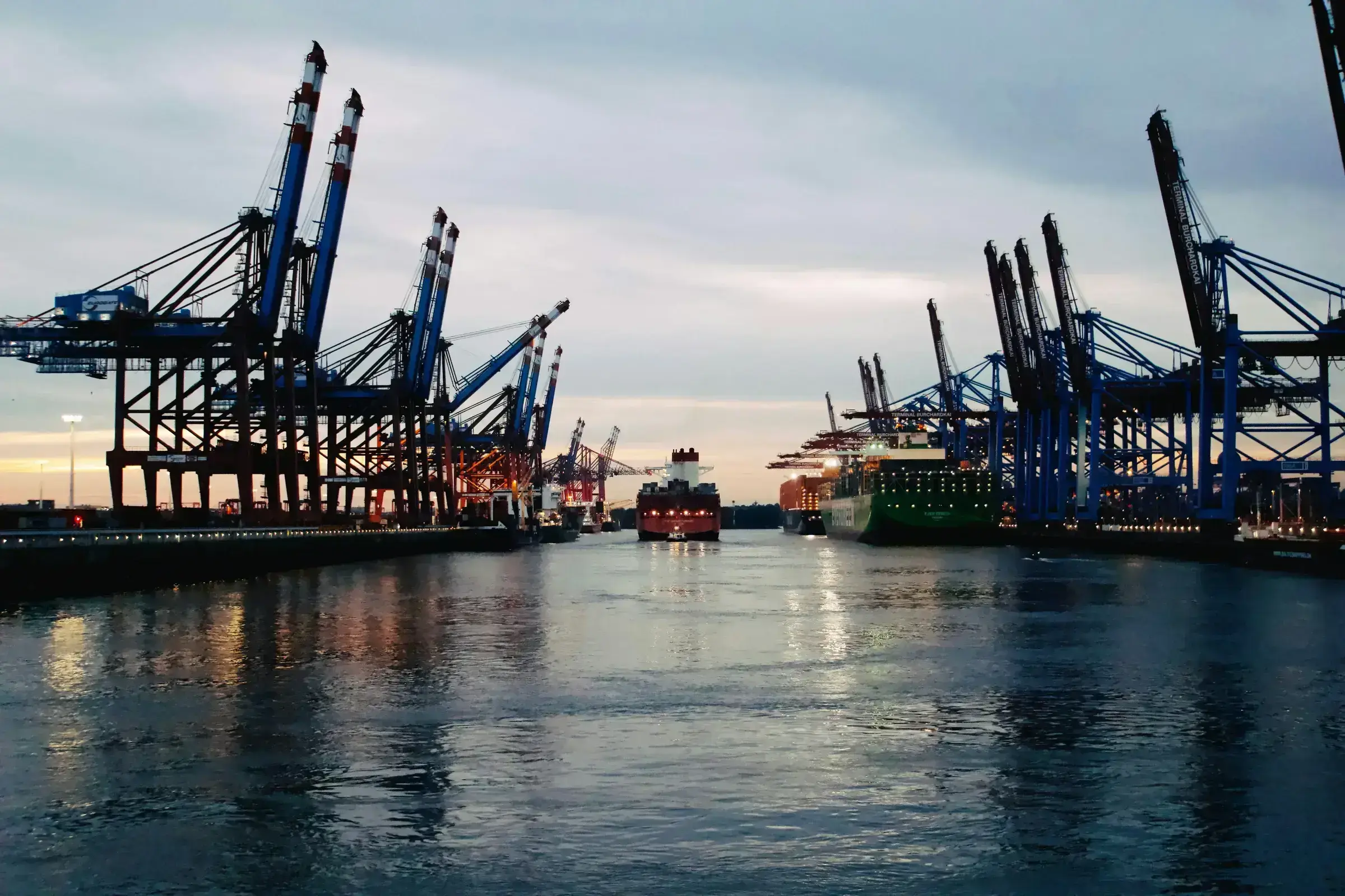 A working port with cargo and crane activity — the practical machinery of economic multiplier effects in motion.