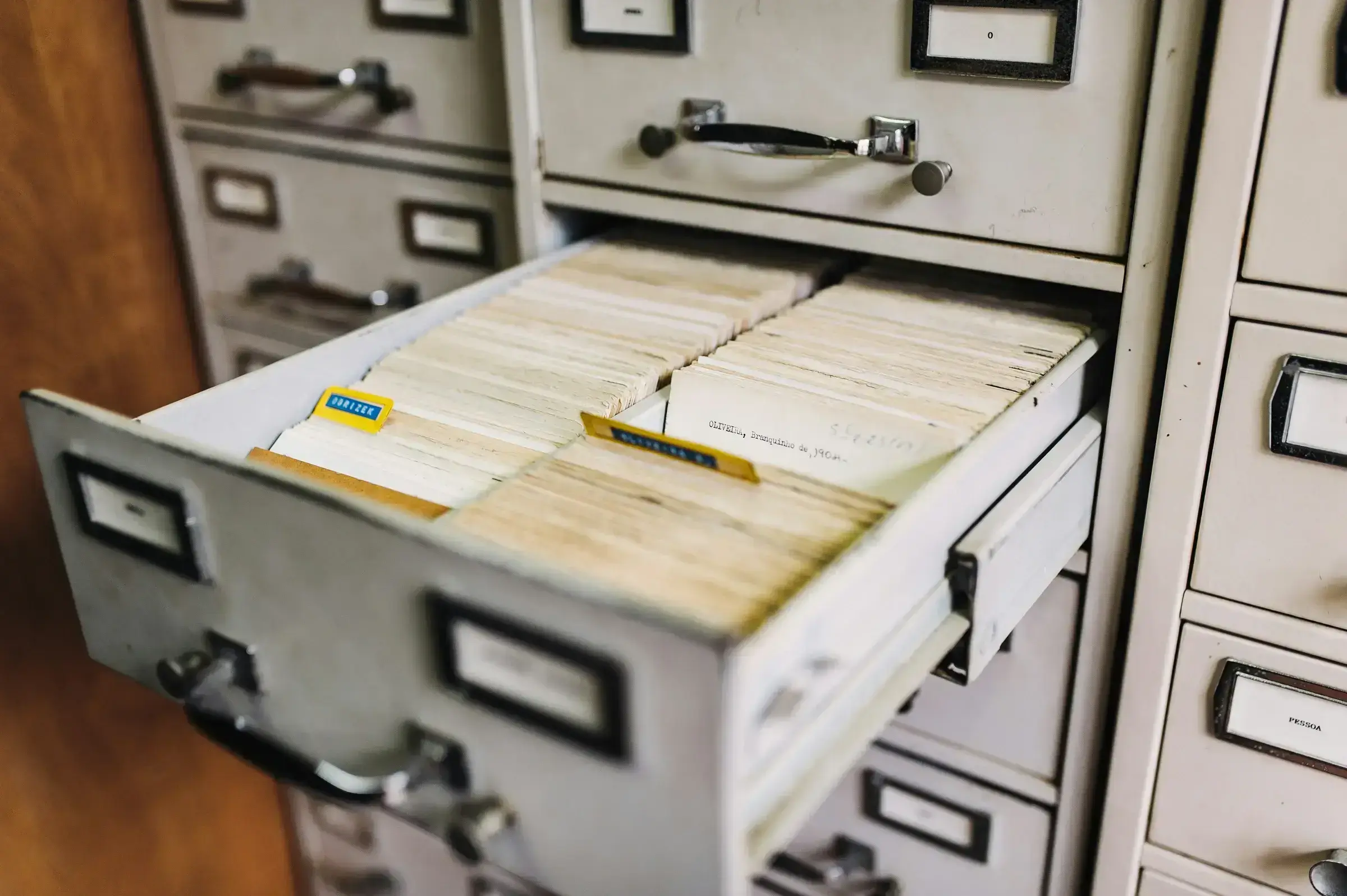 An overhead view of paper documents and folders on a clean desk surface, suggesting the formal documentary work of a citizenship application.