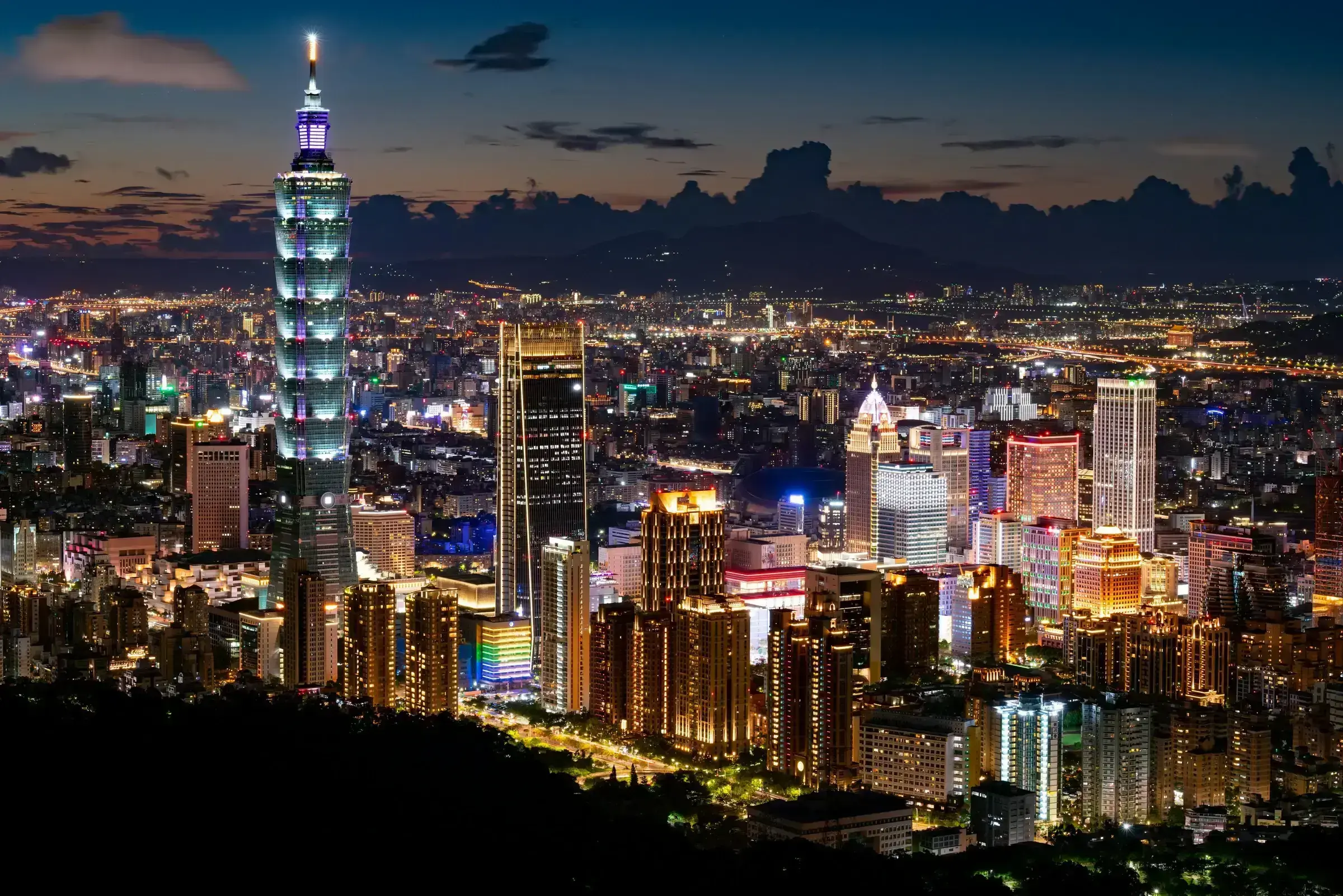 The Taipei skyline at dusk, including Taipei 101 rising above the city — Taiwan's principal commercial hub.