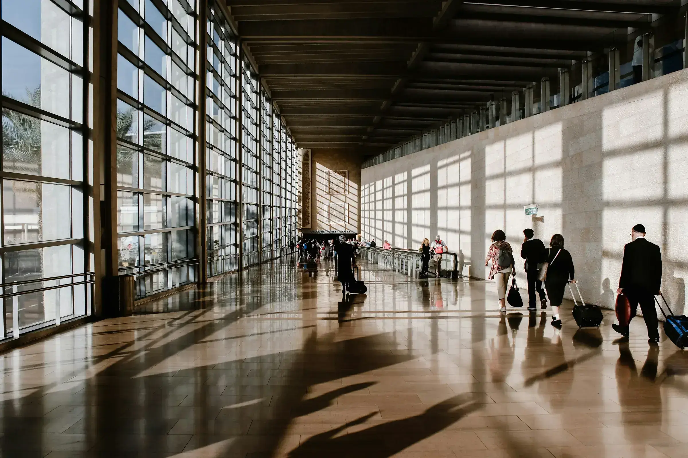The departures hall of a major European international airport, with travellers moving through the terminal.