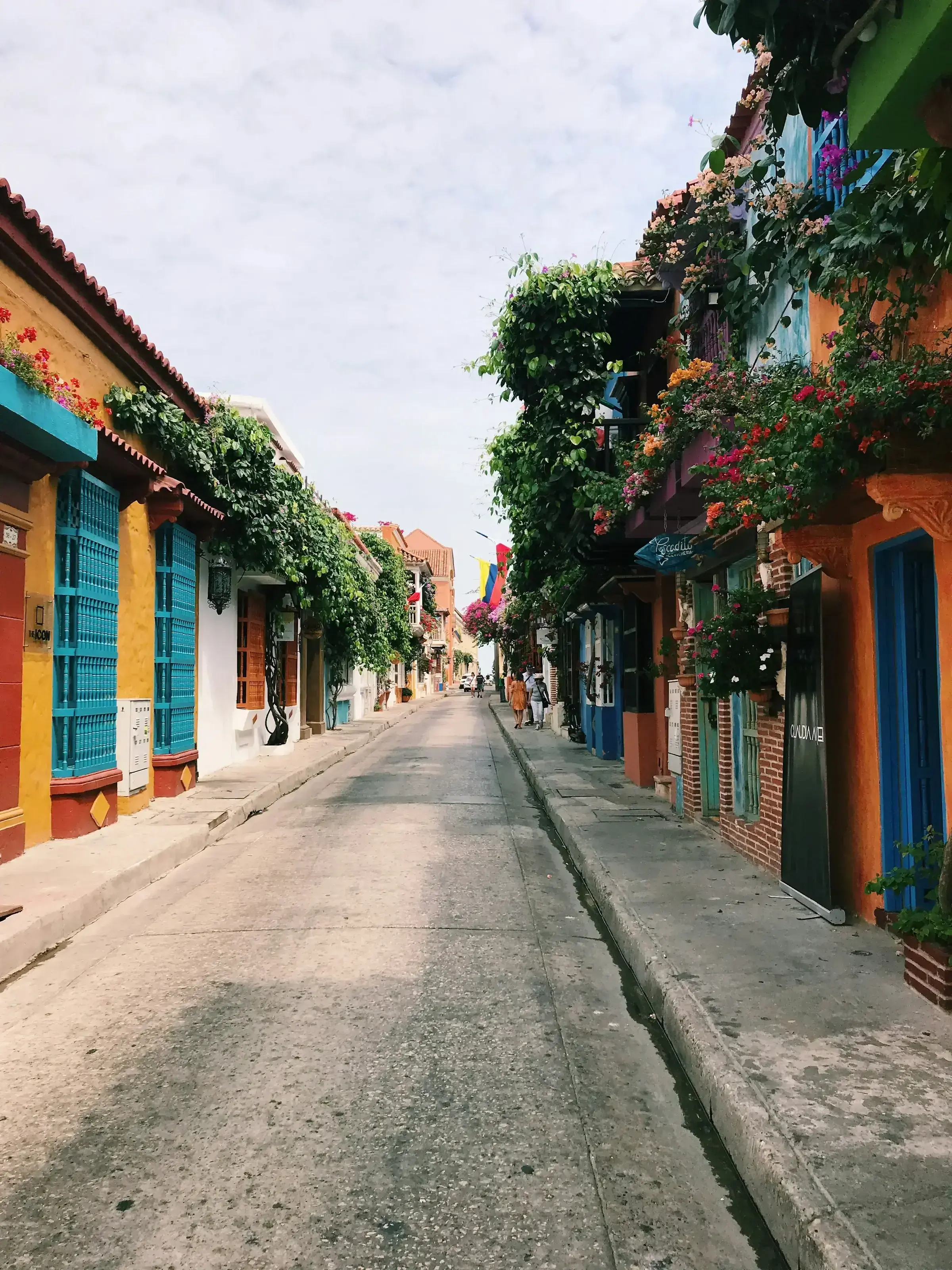 A vibrant colonial street in the wider Caribbean region, lined with brightly painted facades and balconies.