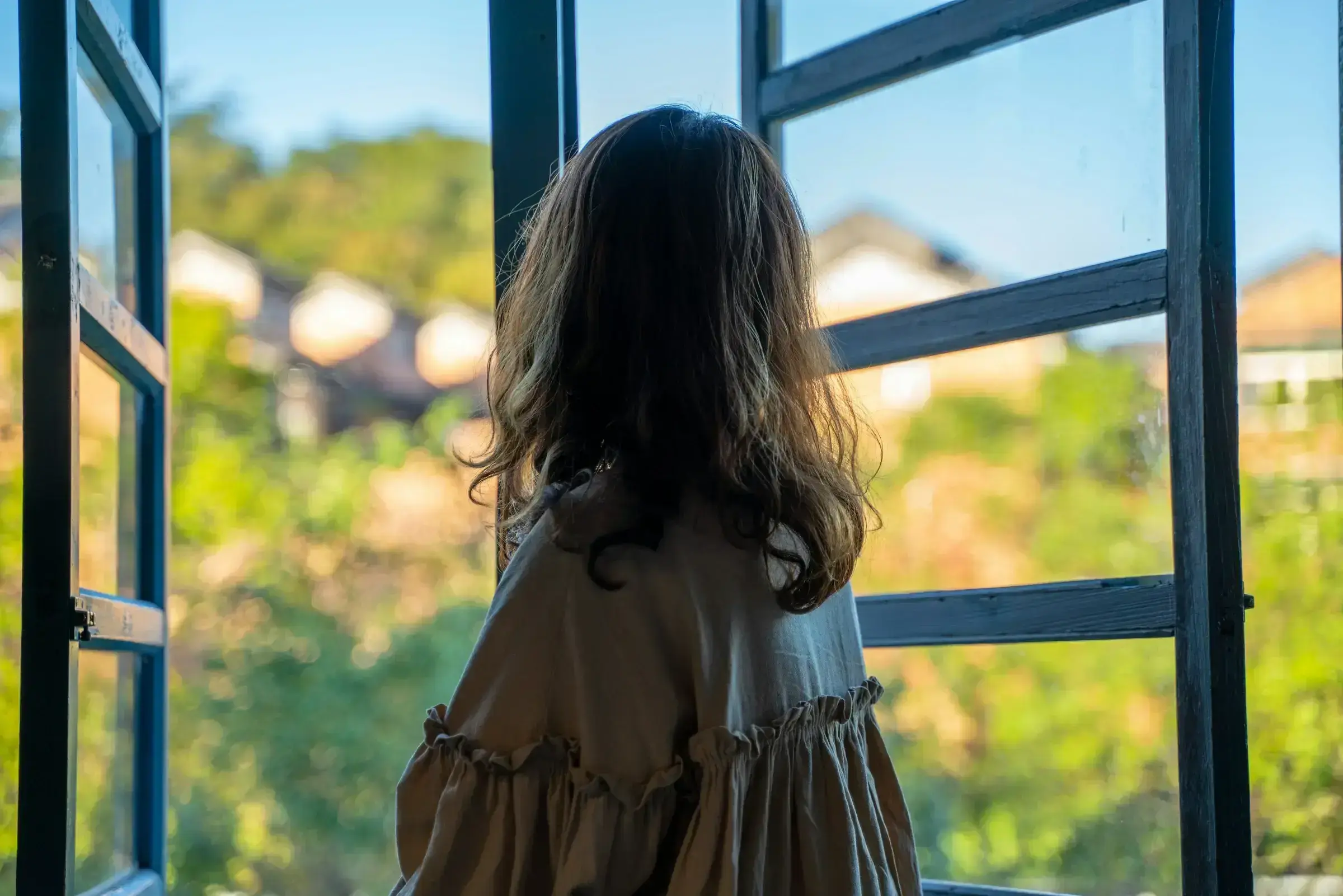 A child framed in soft natural light, looking outward — a quiet image of the future-optionality that a second citizenship provides for the next generation.