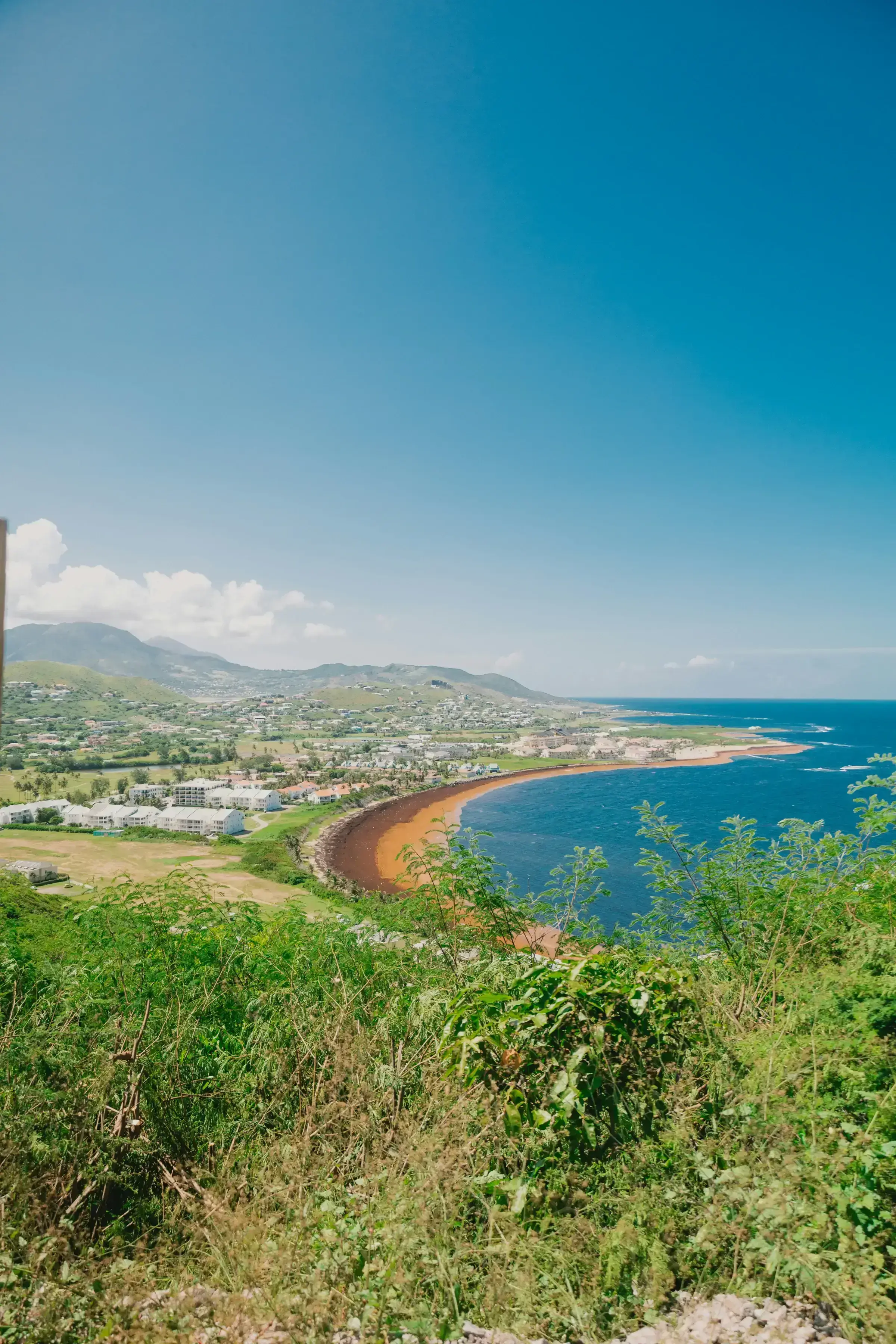 A hilltop view across South Frigate Bay and the Southeast Peninsula of St Kitts, looking toward Nevis on the horizon.