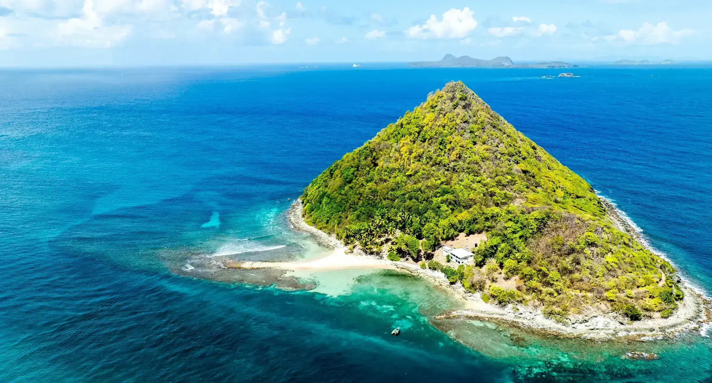 A Caribbean coastline image with deliberate stillness — the visual code of restoration and resilience.