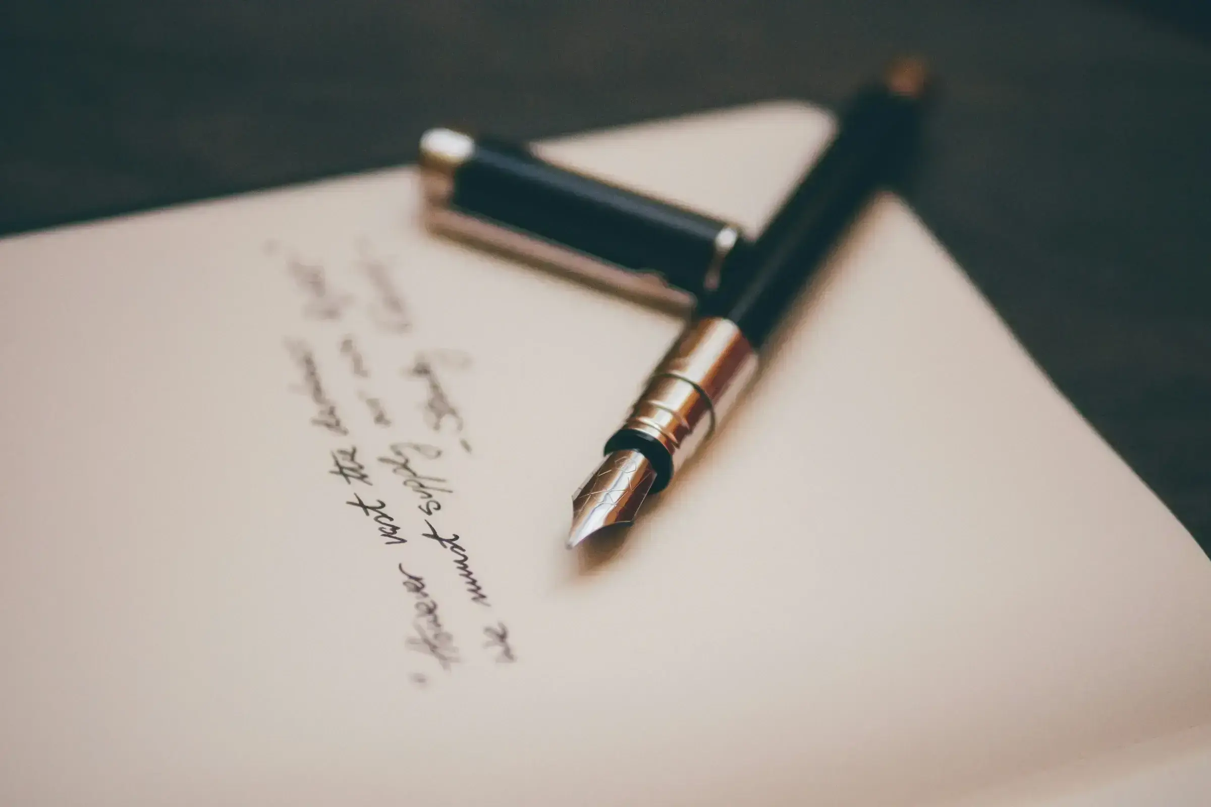 An open journal beside a fountain pen on a clean desk — the visual register of considered decision-making.