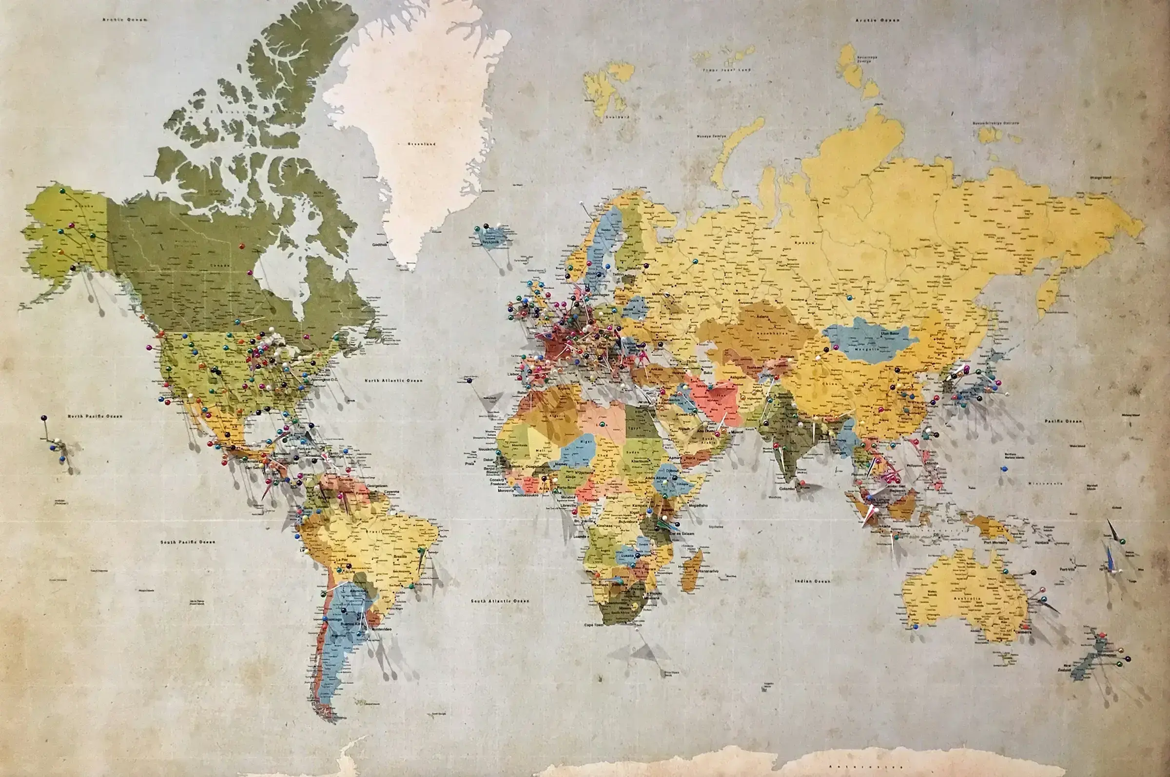 A coloured world map rendered in blue, green and yellow, photographed in close-up.