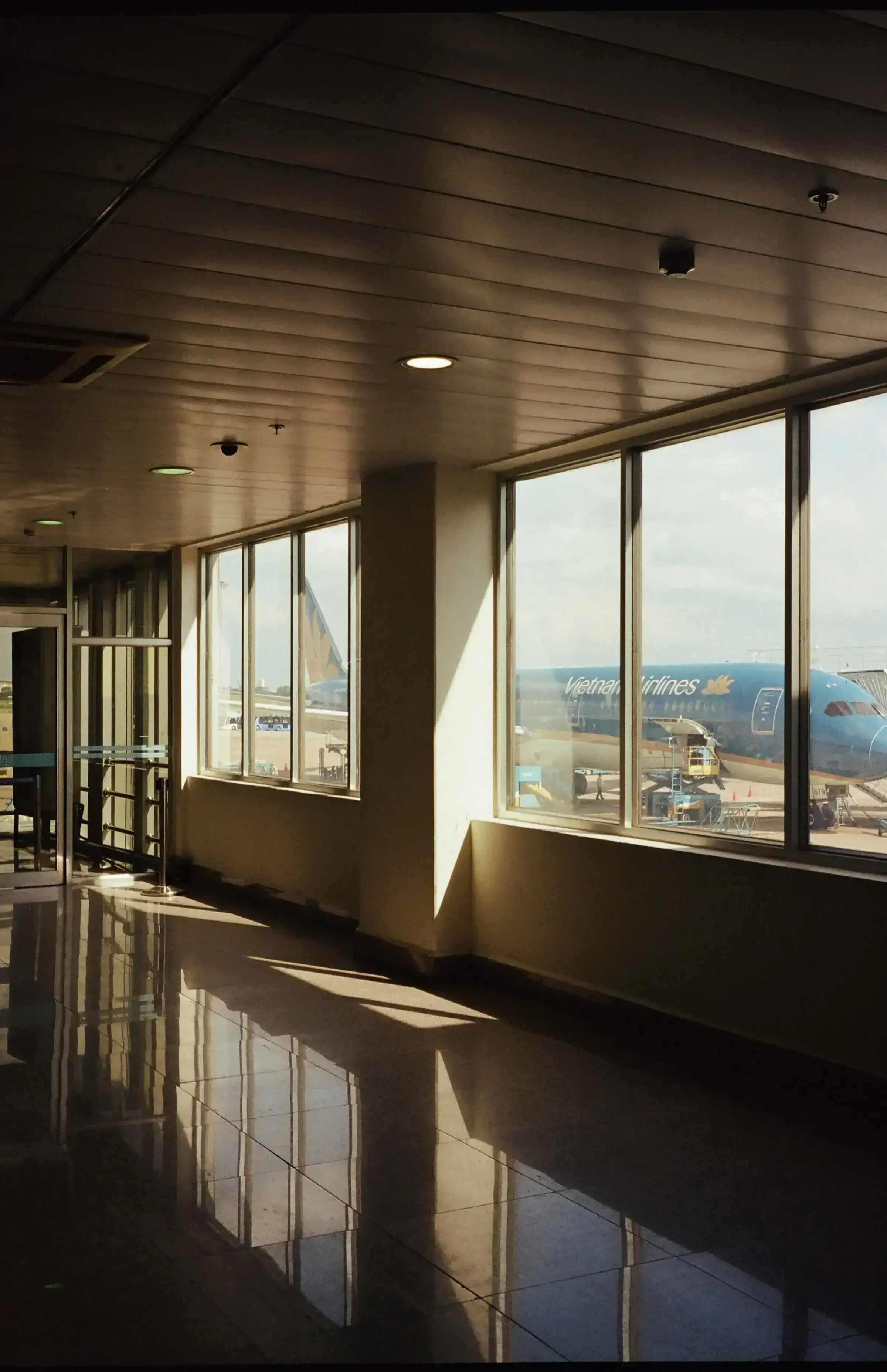 An empty airport gate area at golden hour, the soft pause before a first journey.