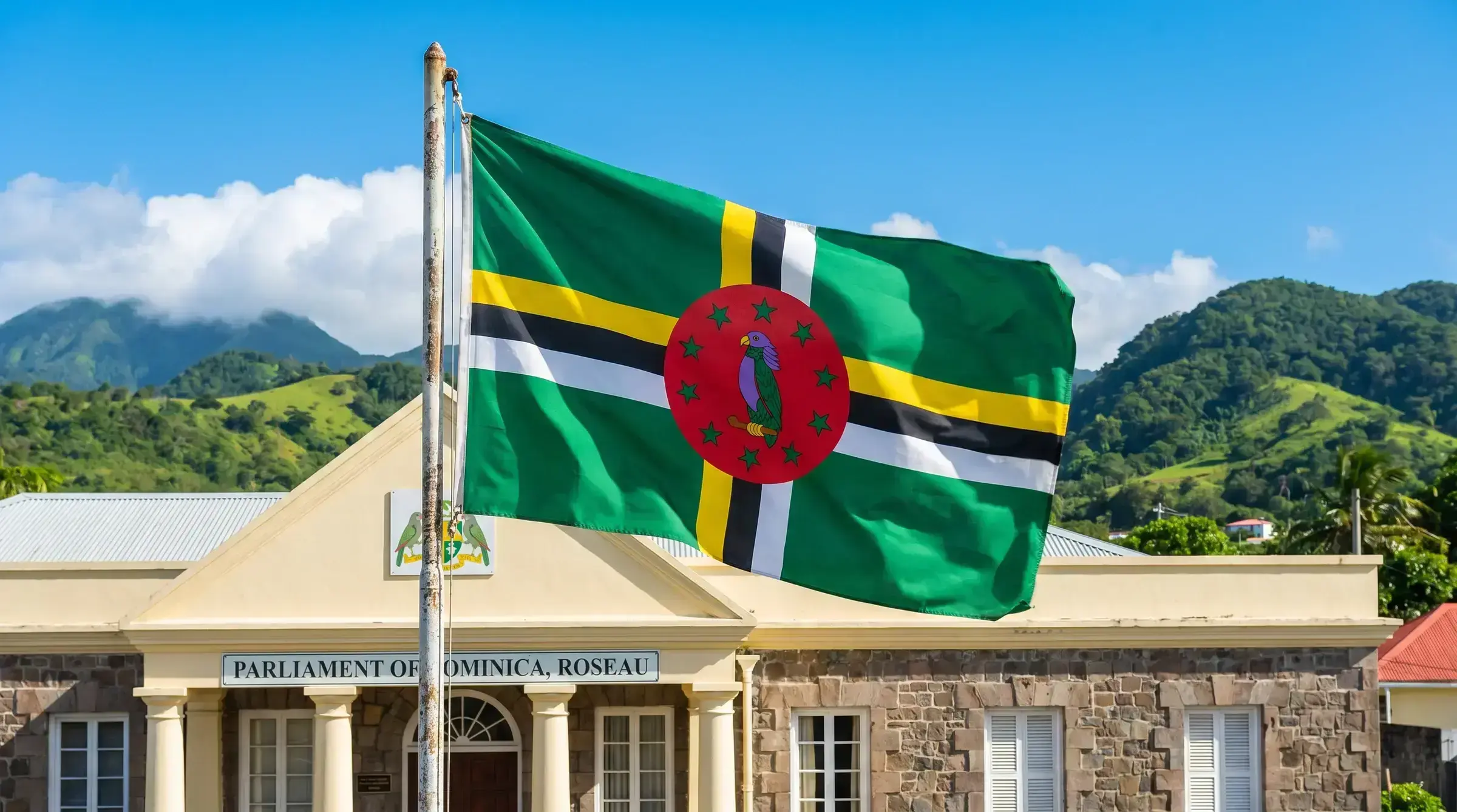The flag of Dominica flying at a government building.