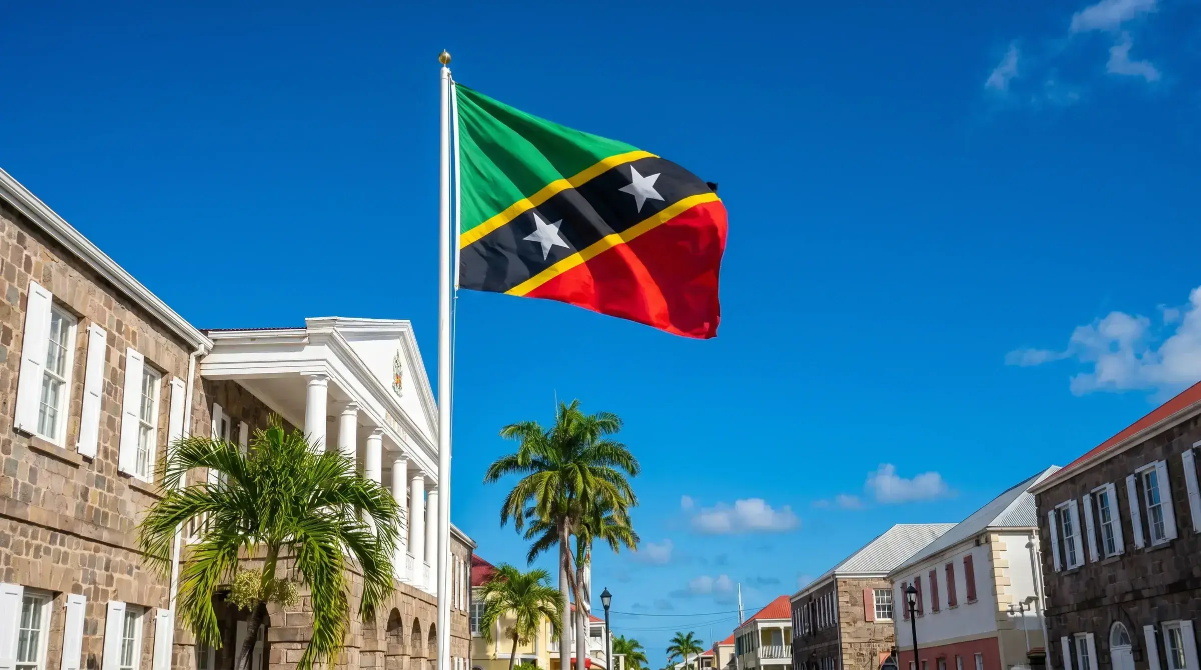 The flag of St Kitts and Nevis flying at a government building.